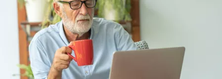 Älterer Mann arbeitet am Laptop