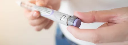 Eine Person hält einen Insulinpen in der Hand.
