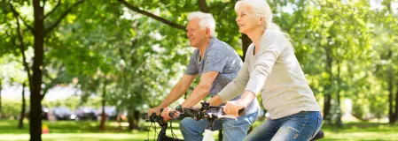 Paar fährt zusammen Fahrrad im Park