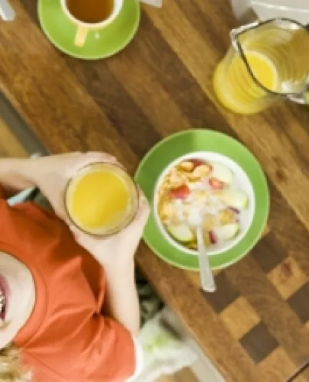 Kind mit Orangensaft schaut nach oben