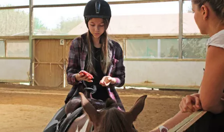 Mädchen auf Pferd mit Messgerät
