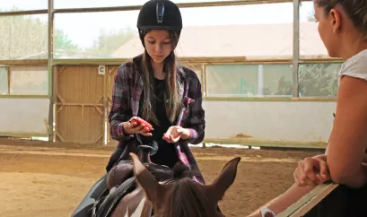 Mädchen auf Pferd mit Messgerät