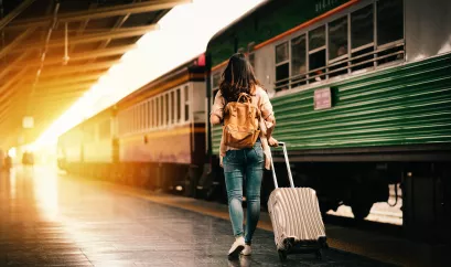 Frau mit Koffer am Bahnsteig