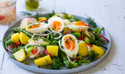 Sommersalat mit Kartoffeln, grünen Bohnen, Spargel, Erbsen, Radieschen und halbierten hartgekochten Eiern