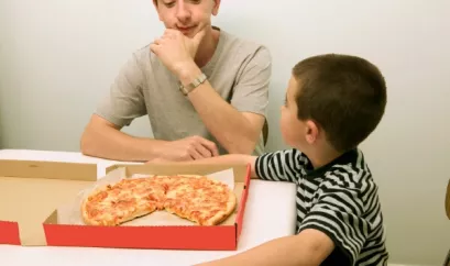 Kind und Vater essen Pizza